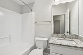 A white bathroom with a toilet, sink, and bathtub.